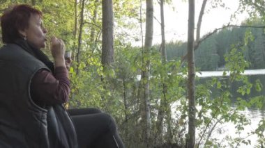 The view of the nature reserve with the lady snacking in Espoo Finland while having her tea break.geology shot.4k