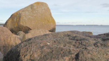 Huge rocks on the shore of the sea on a closer look with the view of the sea across