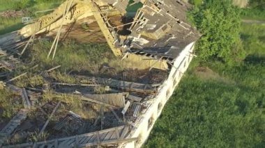 Koeru.Estonia-July 5.2021: Aerial shot of a destroyed soviet cattle barn. Nature taking over decaying buildings. Camera slowly moving backwards and tilting upwards.