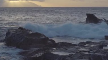Big rocks on the middle of the ocean in Teno Canary Islands with the sea waves on a sunset in the sky.geology shot.4k