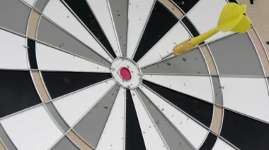 Closeup shot of colourful darts being thrown at a dartboard. Brass barrels. Good pastime activity. Fun game and also a sport. Brass barrels.