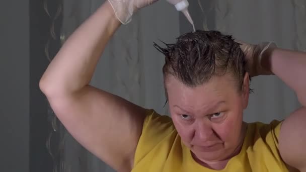 Середньолітня Жінка Фарбує Волосся Використовуючи Барвник Волосся Білі Гумові Рукавички — стокове відео