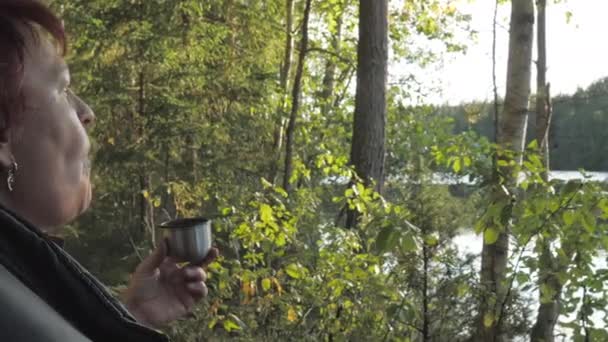 在芬兰埃斯波的森林里喝茶时 这位女士正在吃饼干 — 图库视频影像