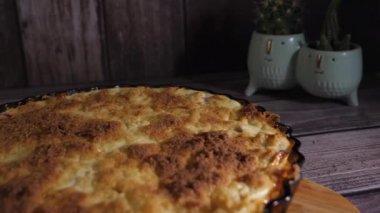 Ahşap bir masanın üzerinde cam bir şekle bürünmüş pastayı yakından çek. Kesme tahtası. Arka planda kaktüs bitkileri var. Lezzetli ev yapımı yemekler. Kamera sola dönerken yavaşça geri hareket ediyor.