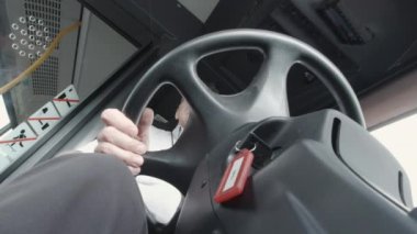 Anahtar Helsinki Finlandiya 'da direksiyonun kenarında otobüs şoförü koltuktayken asılı. Kamera aşağıdan yukarıya bakıyor. Yavaş çekim.