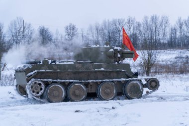 - Rusya. Saint-Petersburg 'da. Krasnoselsky bölgesi. 12 Aralık 2021. Tikhvin şehrinin kurtuluşu savaşının yeniden inşası. Kırmızı bayraklı bir Sovyet T-7 tankı saldırıya geçiyor..