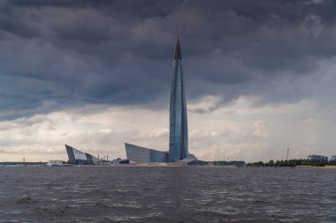 - Rusya. Saint-Petersburg 'da. 24 Haziran 2021. Finlandiya Körfezi 'nden havanın bulutlu olduğu Lakhta Merkezi' nin kule ve binalarının manzarası.