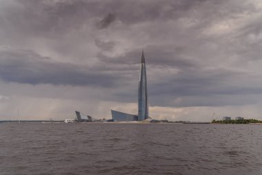 - Rusya. Saint-Petersburg 'da. 24 Haziran 2021. Finlandiya Körfezi 'nden havanın bulutlu olduğu Lakhta Merkezi' nin kule ve binalarının manzarası.