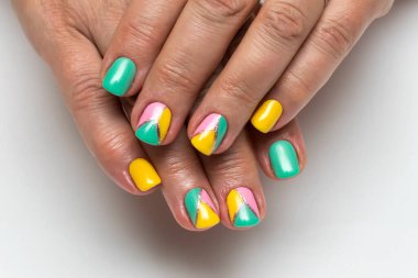 Sarı, pembe, yeşil, nane manikürü ve kare çivili gümüş şerit.