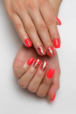 Mercan, uzun kare çivili kırmızı manikür ve altın folyo.