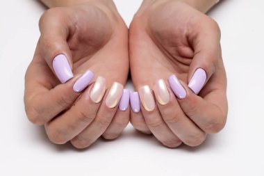 Leylak, pembe, çıplak, parlak, inci kokulu manikür beyaz arka planda kristallerle uzun kare çiviler üzerinde.