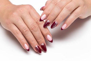 Gümüş çizimli Burgundy Fransız manikürü, beyaz arka planda uzun keskin tırnaklı çizgiler.