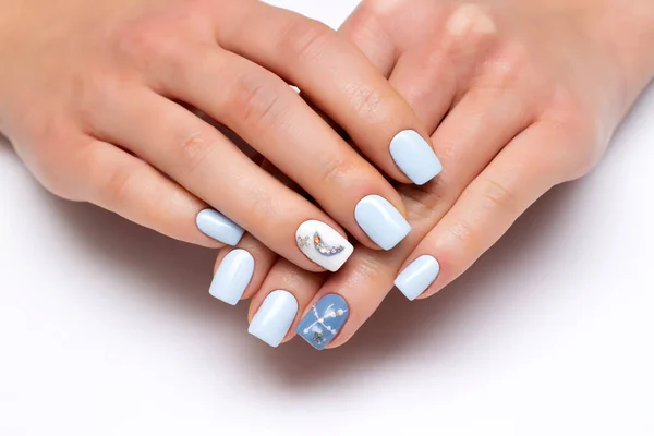 Extension gel manicure. Light blue, heavenly, blue manicure with moon, crystal dots on long square nails close-up on a white background. Christmas manicure.