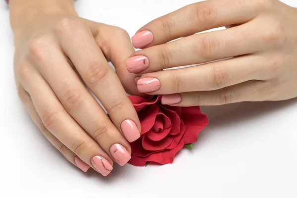 pink manicure with gold strips on square short nails with a red rose in the palms of the hands