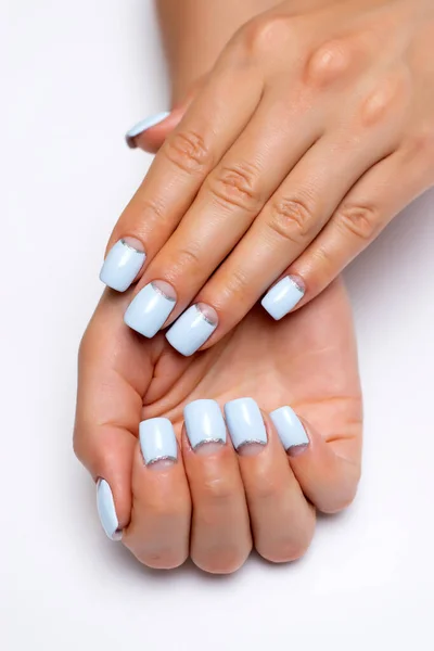 Blue moon manicure with a silver strip on long square nails close-up on a white background. Gel design.