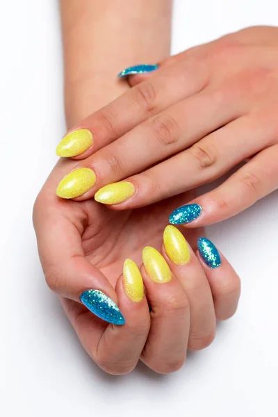 Gel nail design. Yellow-blue manicure on sharp long nails on a white background close-up. Patriotic manicure. Ukraine.