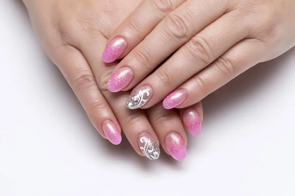 Gel nail design. Shiny pink, silver manicure with white lace, monograms, abstraction on short oval nails close-up on a white background