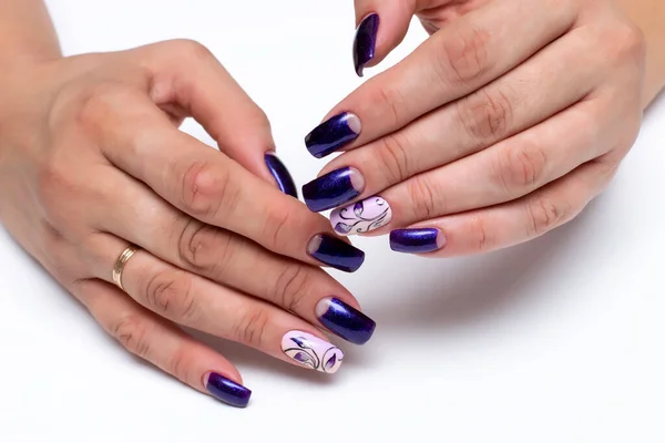 Gel manicure with flowers. Blue shiny, purple shiny moon manicure on long square nails close-up on a white background. Abstraction.