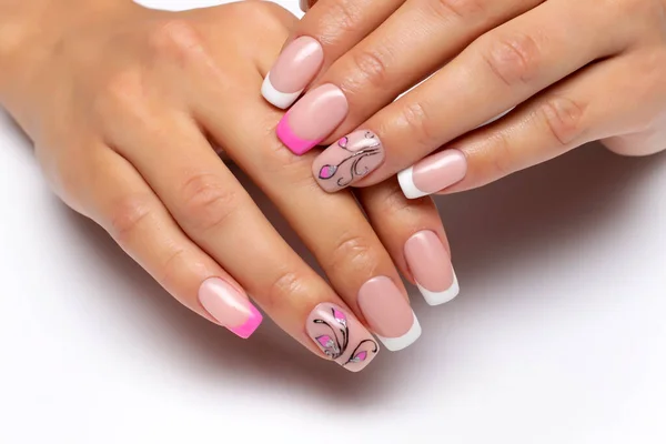 Gel nail design. French pink-white manicure with drawings, flowers and monograms on short square nails close-up on a white background.