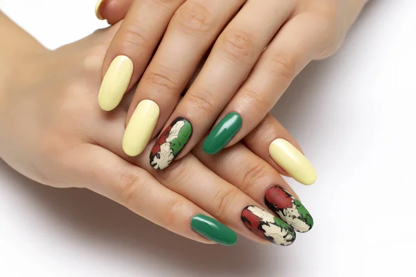 Autumn yellow, green, black, orange, cracked manicure on long oval nails close-up on a white background. Gel fashion design.