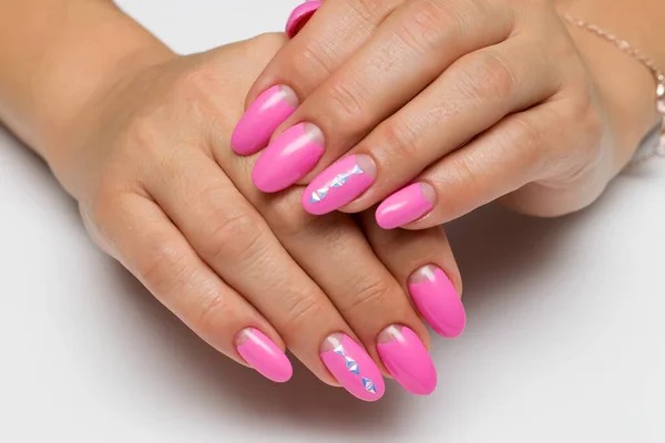 pink moon manicure on long oval nails with triangles, crystals on a white background