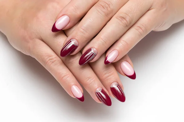 Burgundy French manicure with silver drawings, stripes on long sharp nails close-up on a white background