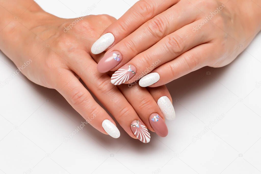 Wedding summer manicure. Drawn shell with crystals. White sequins. Delicate beige manicure on long oval nails on a white background. Summer manicure.