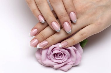 Fransız beyazı düğün, ellerinde pembe bir gülle oval tırnaklarında gümüş manikür.