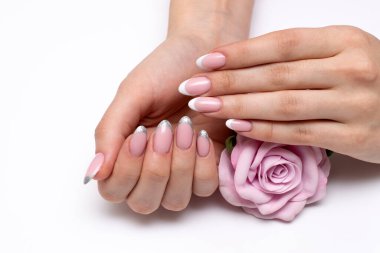Fransız beyazı düğün, ellerinde pembe bir gülle oval tırnaklarında gümüş manikür.