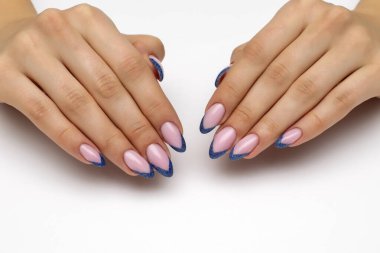 Beyaz arka planda uzun sivri tırnaklı yansıtıcı mavi pullu Fransız manikürü..