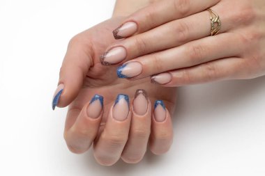 Keskin Fransız manikürlü, dar kare tırnaklı, mavi, kahverengi, kırmızı pullu. Beyaz arkaplanda yakın plan.