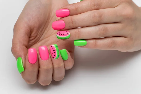 Summer pink and light green manicure with painted watermelons. Vacation manicure. Close-up on a white background. Acid colors of nails. Themed nails.