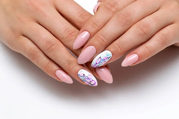 Powdery white manicure on sharp long nails with a distinguished ring finger. Abstraction drawing with crystals, balls. Light pink nails closeup on a white background.