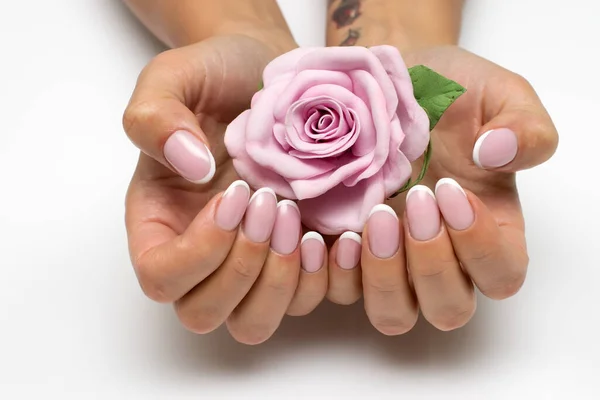 Classic manicure. Wedding nail design. White manicure. French Manicure on oval nails with a pink flower. Rose with nails.