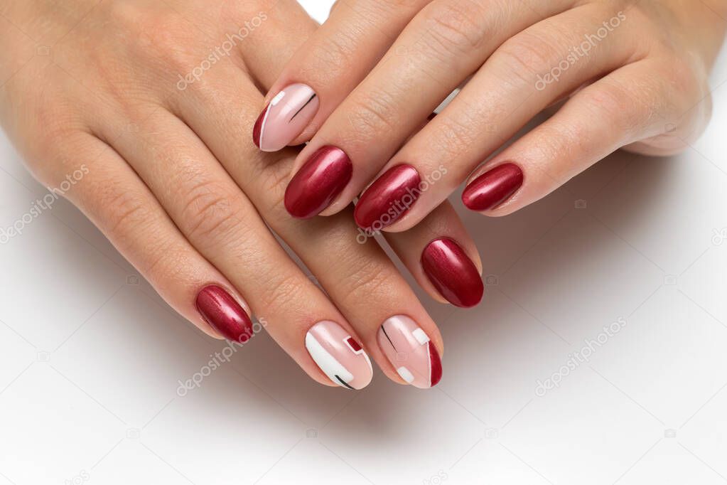 Stylish summer burgundy manicure with white and black abstraction, rectangles on long oval nails on a white background close-up