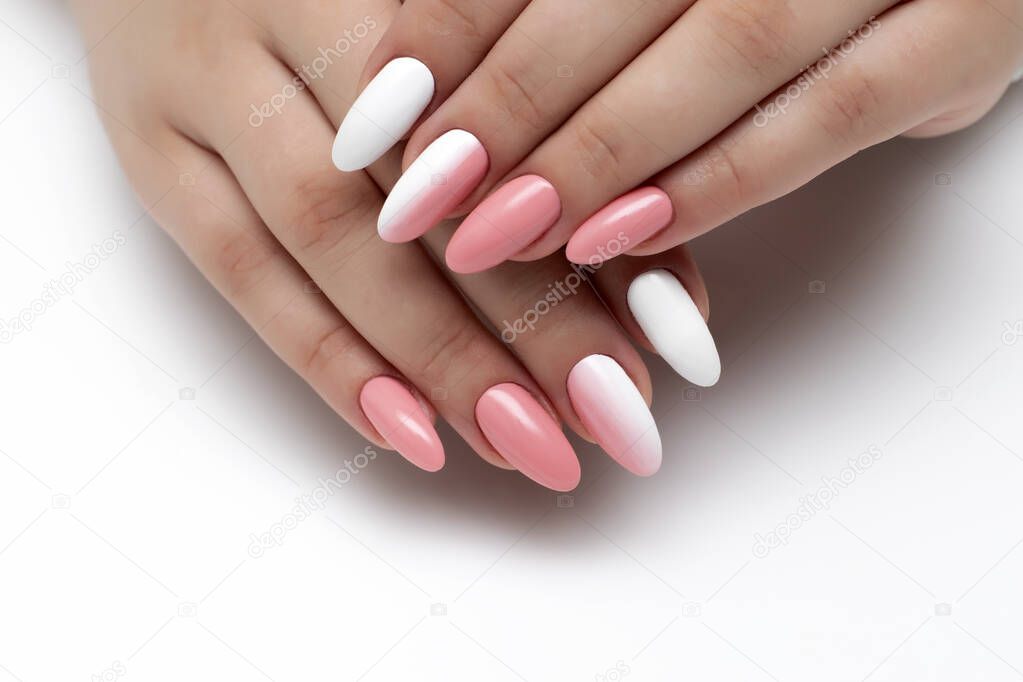 Gel manicure on a white background, close-up. White peach long oval nails, ombre design.