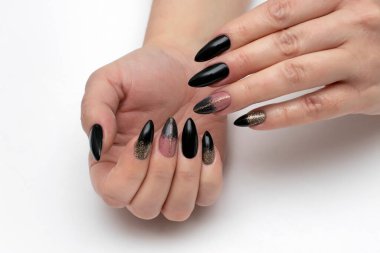 Altın yaldızlı siyah manikür ve beyaz arka planda uzun sivri tırnaklı altın bir şerit..