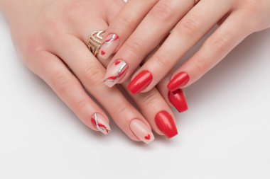 Kalpli kırmızı, bej manikür, altın döküm, kırmızı çizgiler, beyaz arka planda uzun kare çivili dalgalar.