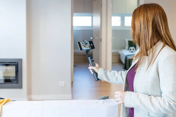 Agente imobiliária feminina fazendo um vídeo com seu gimbal para mostrá-lo a seus clientes em uma chamada de vídeo ou para enviá-lo para redes sociais e promover a venda de um imóvel ou um imóvel para venda. — Fotografia de Stock