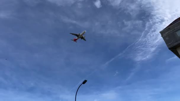 Низколетящие самолеты прибывают в аэропорт назначения недалеко от небольшого города в Европе — стоковое видео