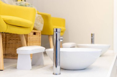 Pedikür için seramik kaseler, musluklar ve sarı koltuklar. Seçici odak