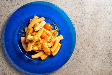 Top view of Rightoni Arrabiata a traditional Italian dish on a concrete background. High quality photo