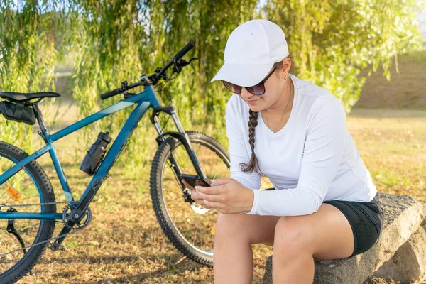 Kız Motosiklet Egzersizinden Sonra Cep Telefonuyla Sosyal Medyayı Kontrol Ediyor — Stok fotoğraf