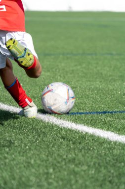 Sahadaki bir futbol topunu tekmelemek üzere olan bir çocuk. Yüksek kalite fotoğraf