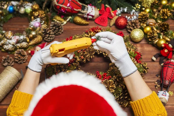 身穿橙色毛衣 头戴白色手套 手持胶水枪的女性手制造圣诞装饰品或玩具 让新年装饰 圣诞装饰品 — 图库照片