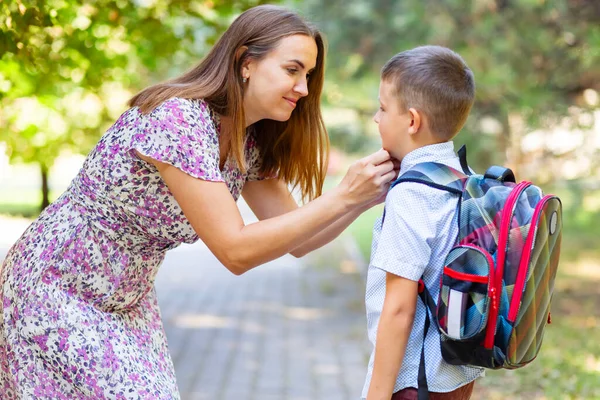 Back to school. Mother saying goodbye to her son as he leave for School. First day at school.