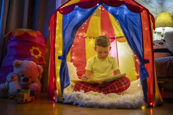 Милый Мальчик Читает Книгу Вечером Палатке — стоковое фото