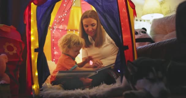 快乐温馨的家庭 年轻的母亲和她的儿子在睡觉的时候在孩子的房间里玩耍 妈妈和可爱的孩子正在室内玩手电筒 家庭概念 — 图库视频影像