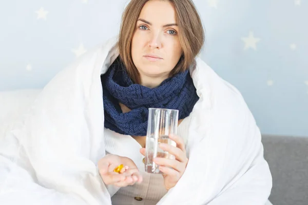 流感治疗或结肠炎 感染流感的女人 裹着温暖的围巾和毛毯 吃着盛着一杯水的药丸 — 图库照片