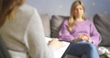 Psikoterapi seansında bir kadın ofisteki psikoloğuyla konuşuyor. Psikoterapi danışmanlığı